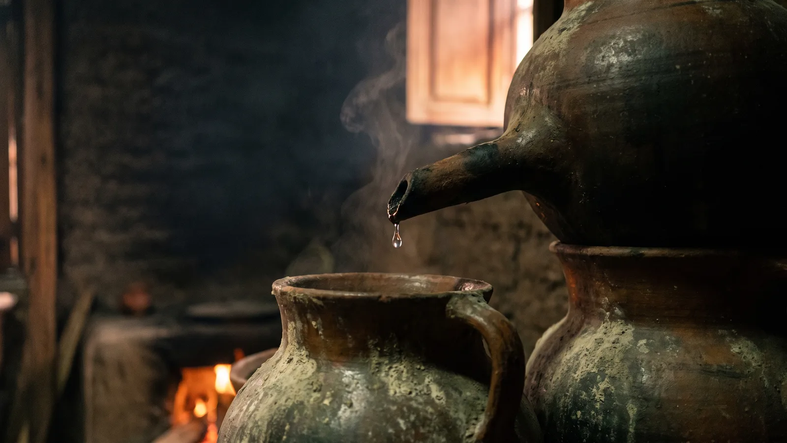 Olla de barro y una gota de destilado formándose.